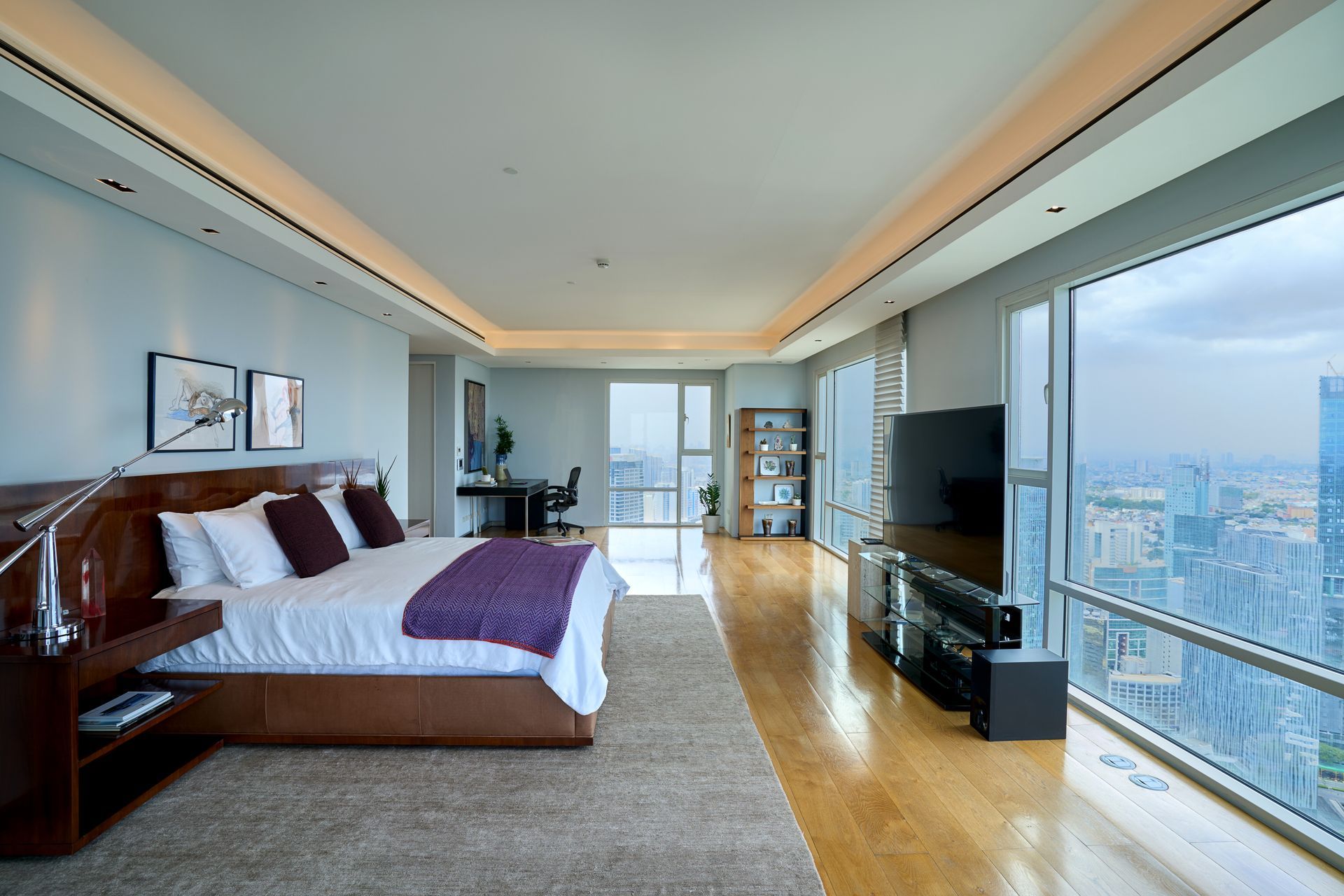 A large bedroom with a king size bed and a large window.