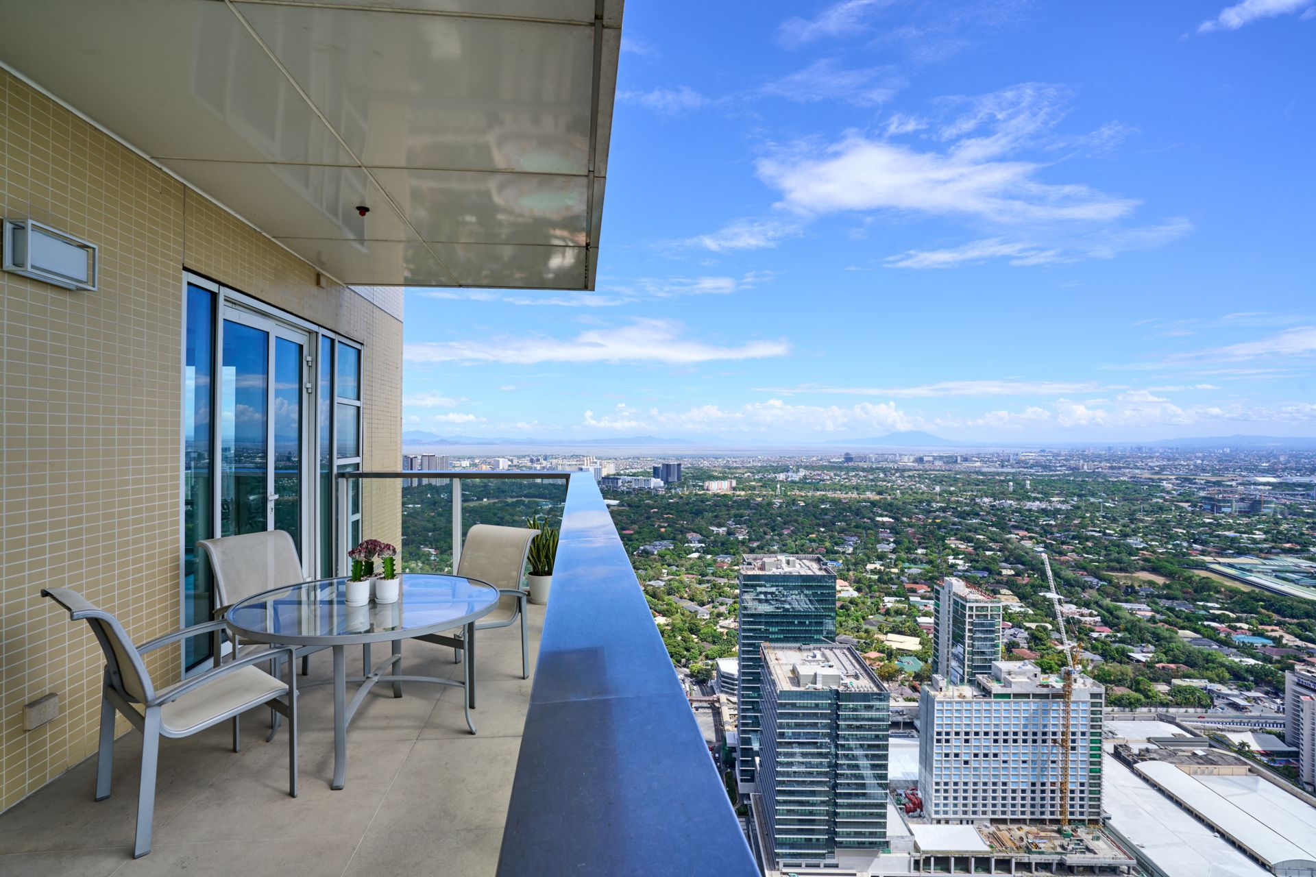 A balcony with a table and chairs overlooking a city.