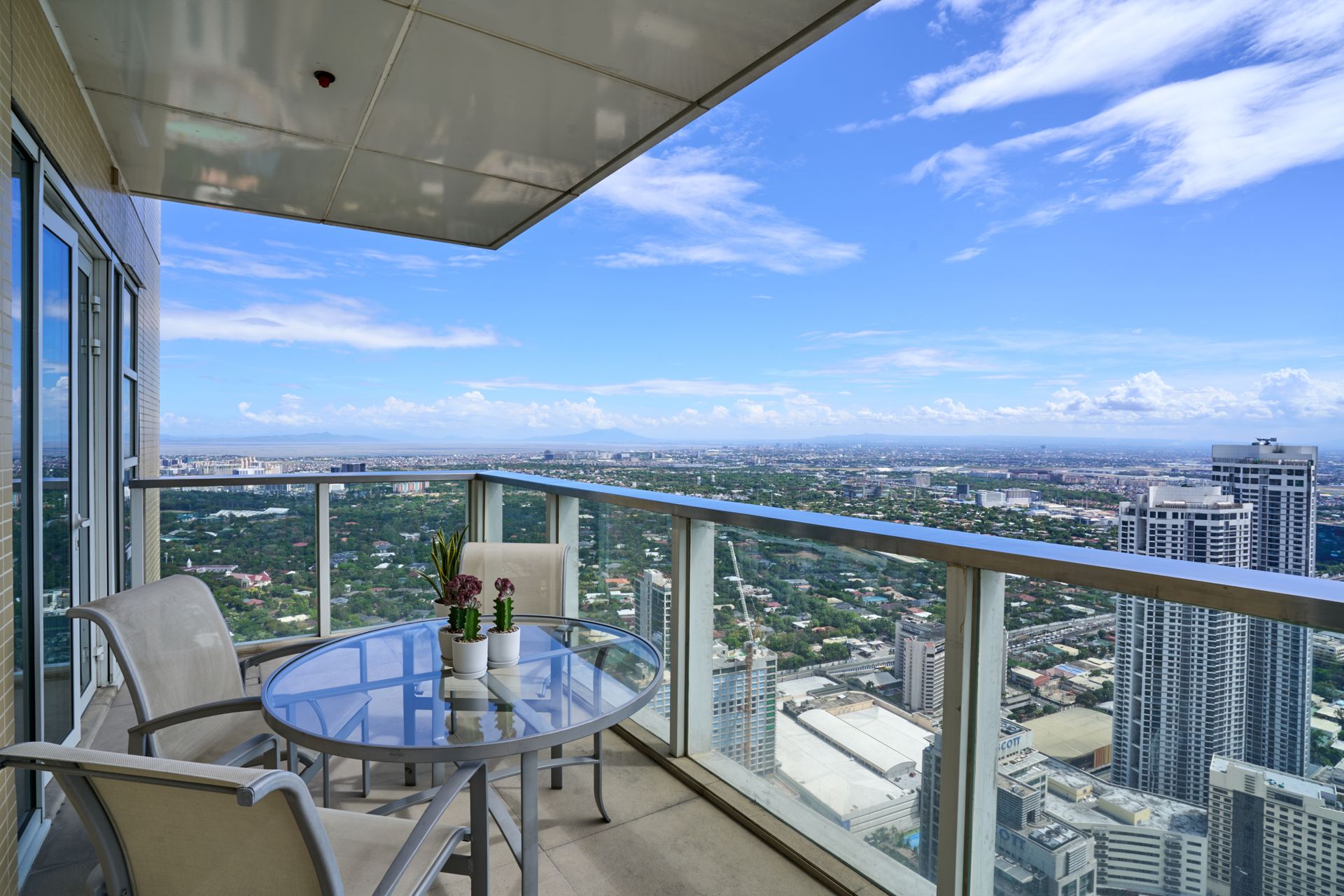 A balcony with a table and chairs overlooking a city