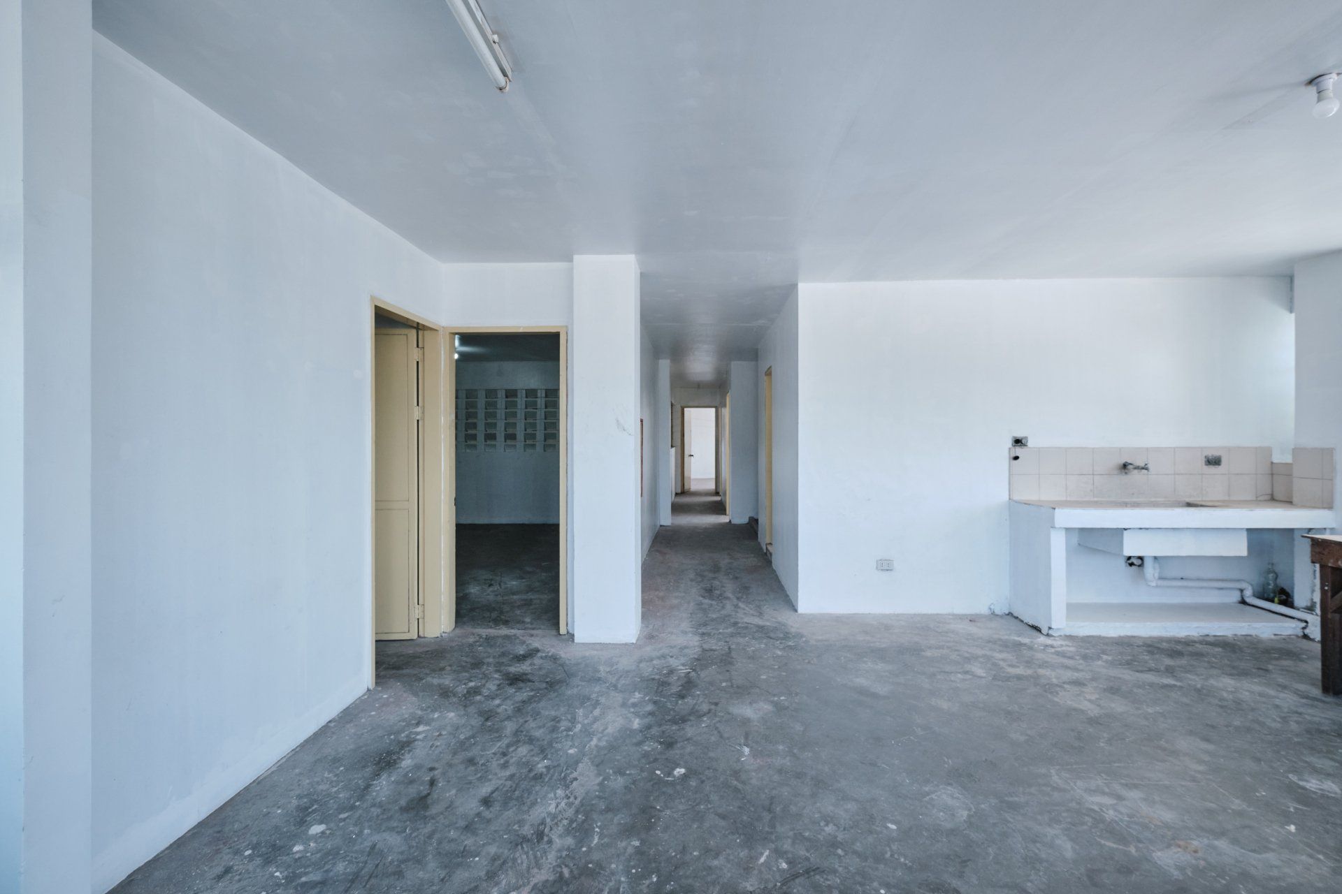An empty room with white walls and a concrete floor.