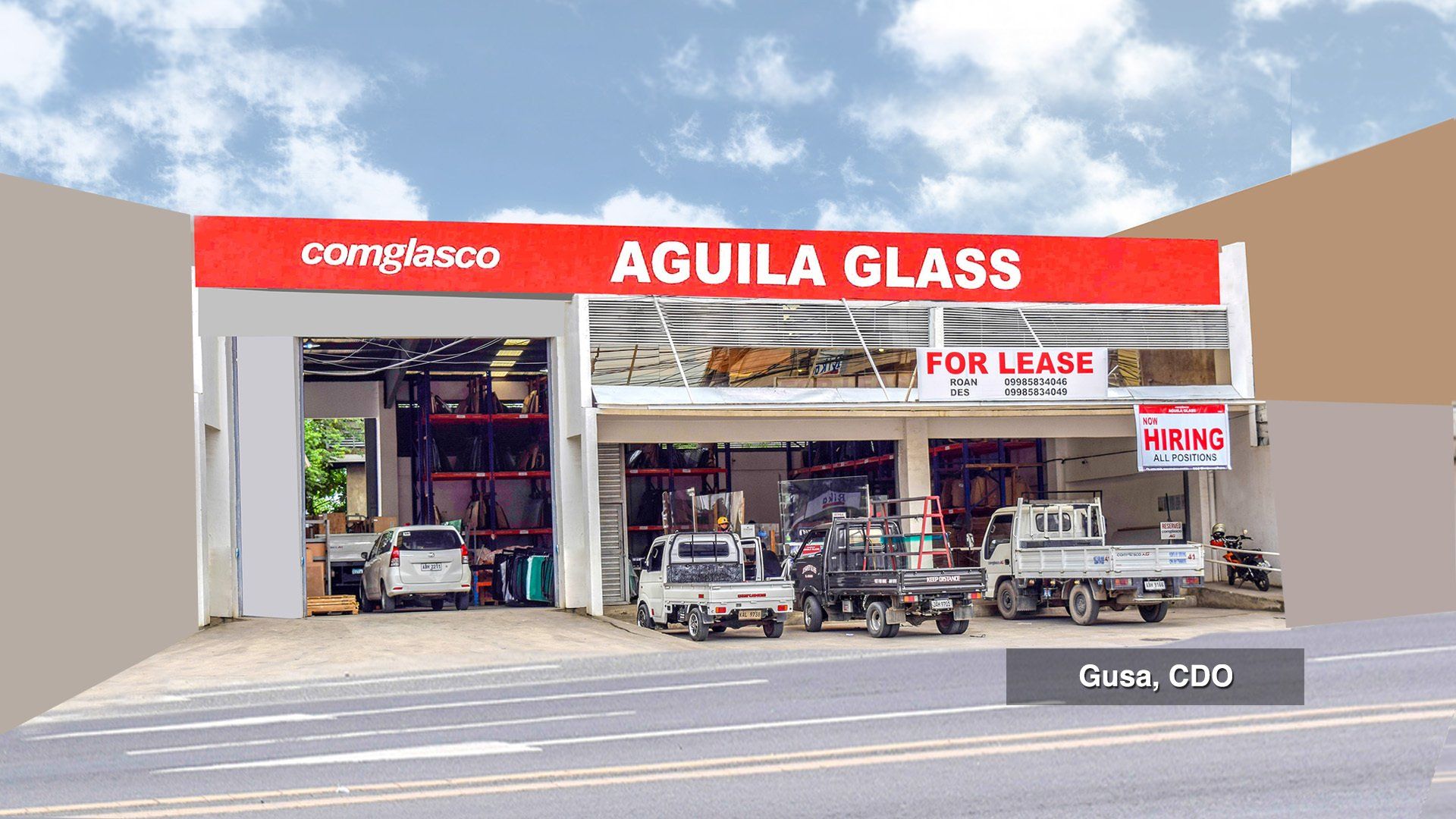 An aguila glass store with cars parked in front of it