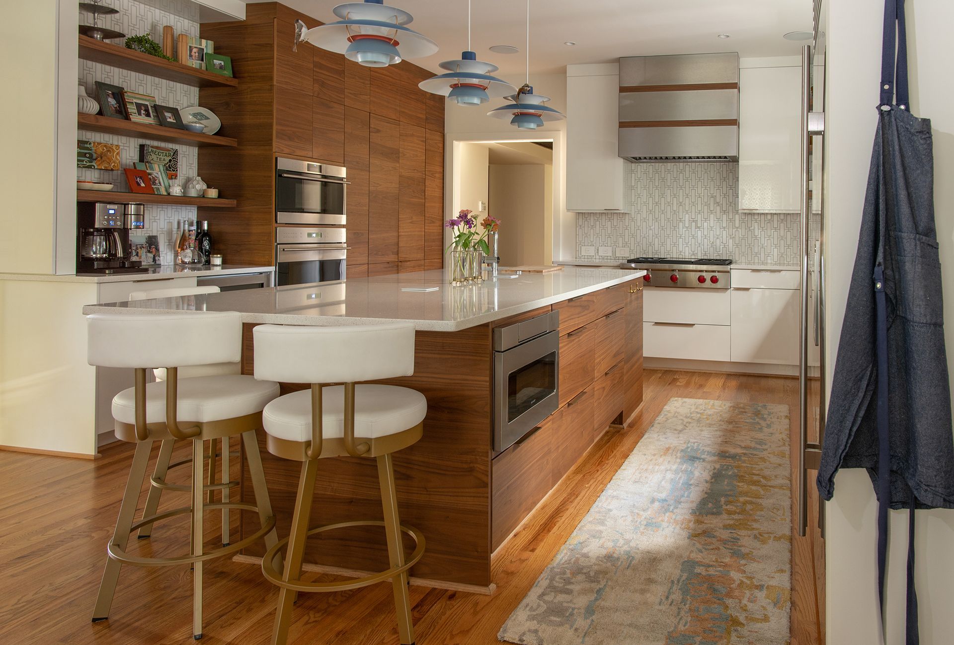 Modern kitchen with wood cabinetry, white island with bar stools, and stainless steel appliances.