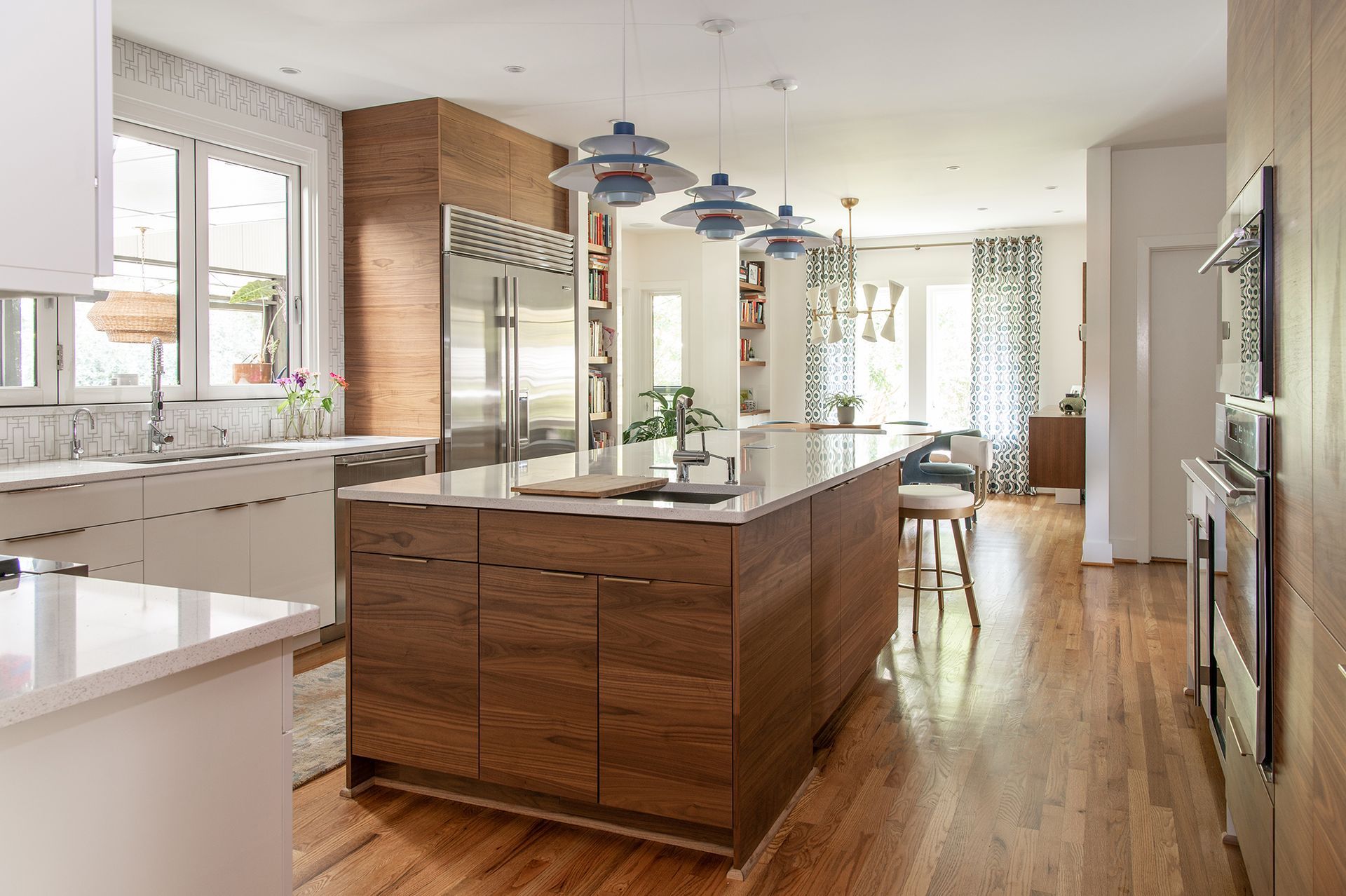 Modern kitchen with wood island, stainless steel fridge, and white countertops.