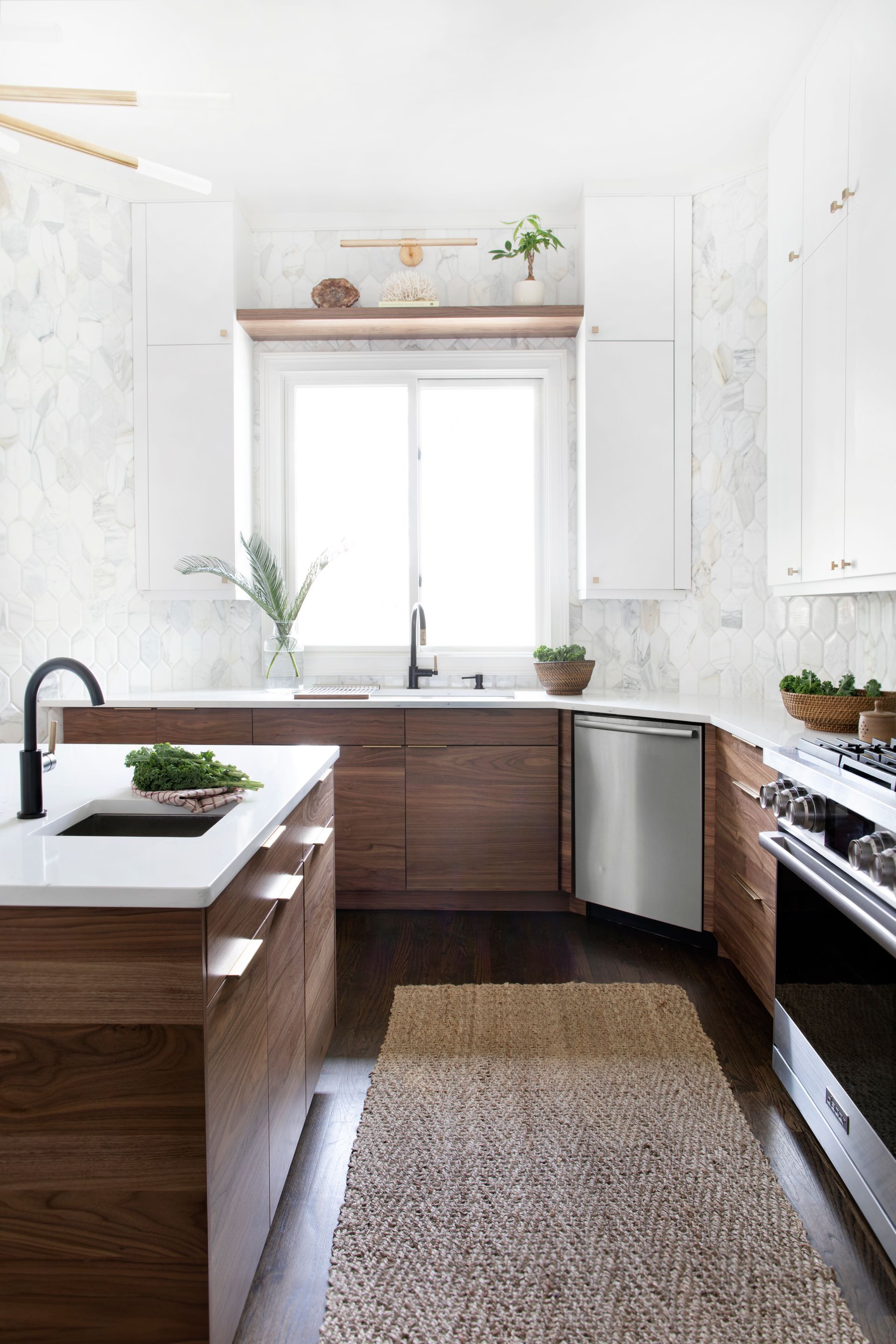 Modern kitchen with wood cabinets, white countertops, stainless steel appliances, and a patterned backsplash.