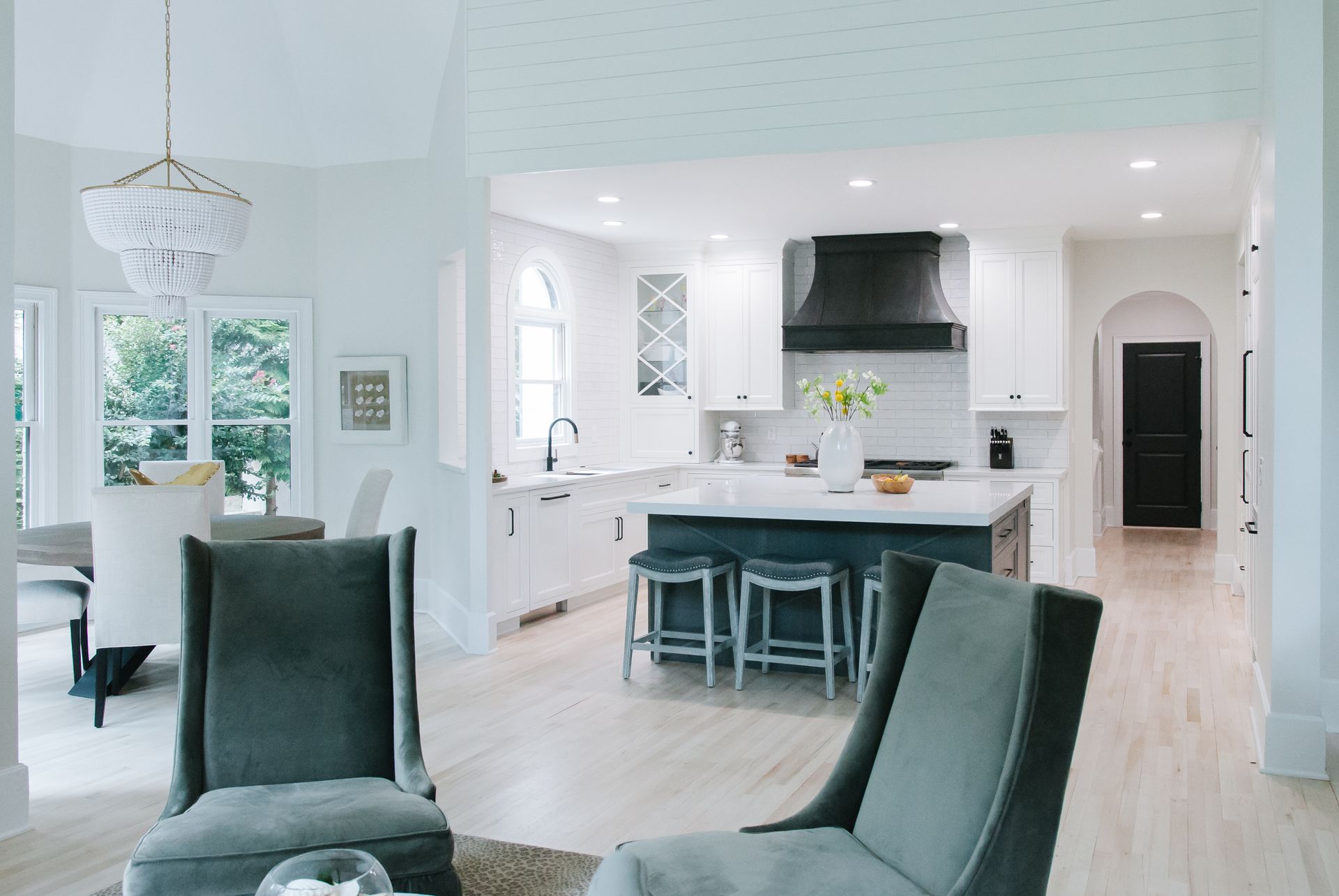 Bright open-concept kitchen and living room with white walls, island, and seating.