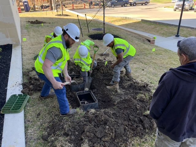 A group of construction workers are digging in the dirt.