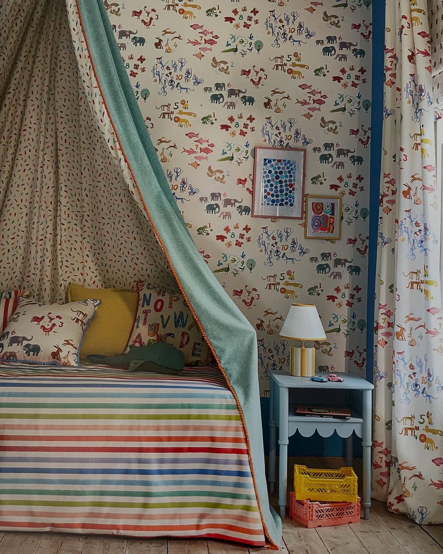 Camera da letto con letto a baldacchino, biancheria da letto a righe colorate, carta da parati con stampa per bambini