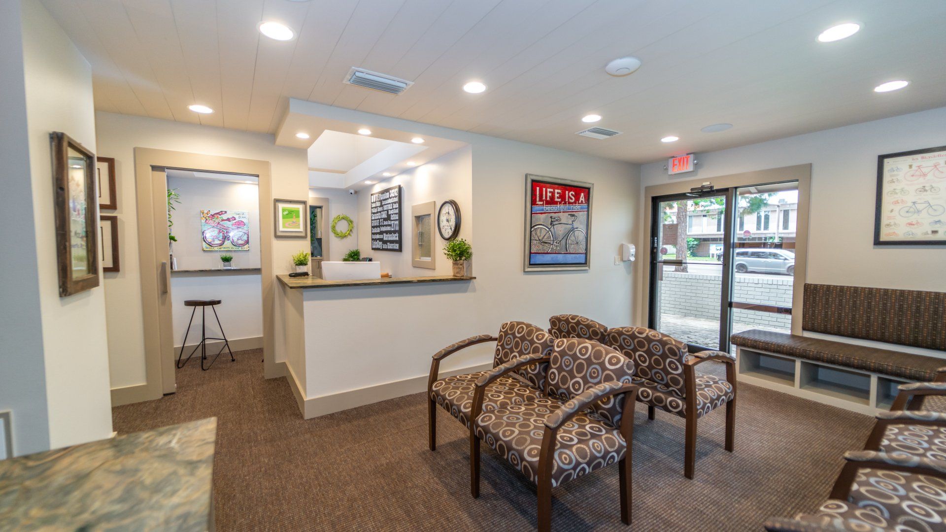 A waiting room with chairs and a counter in a dental office.