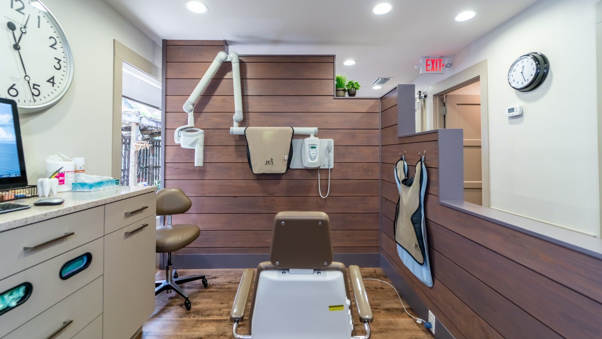 A dental office with a dental chair and a clock on the wall.