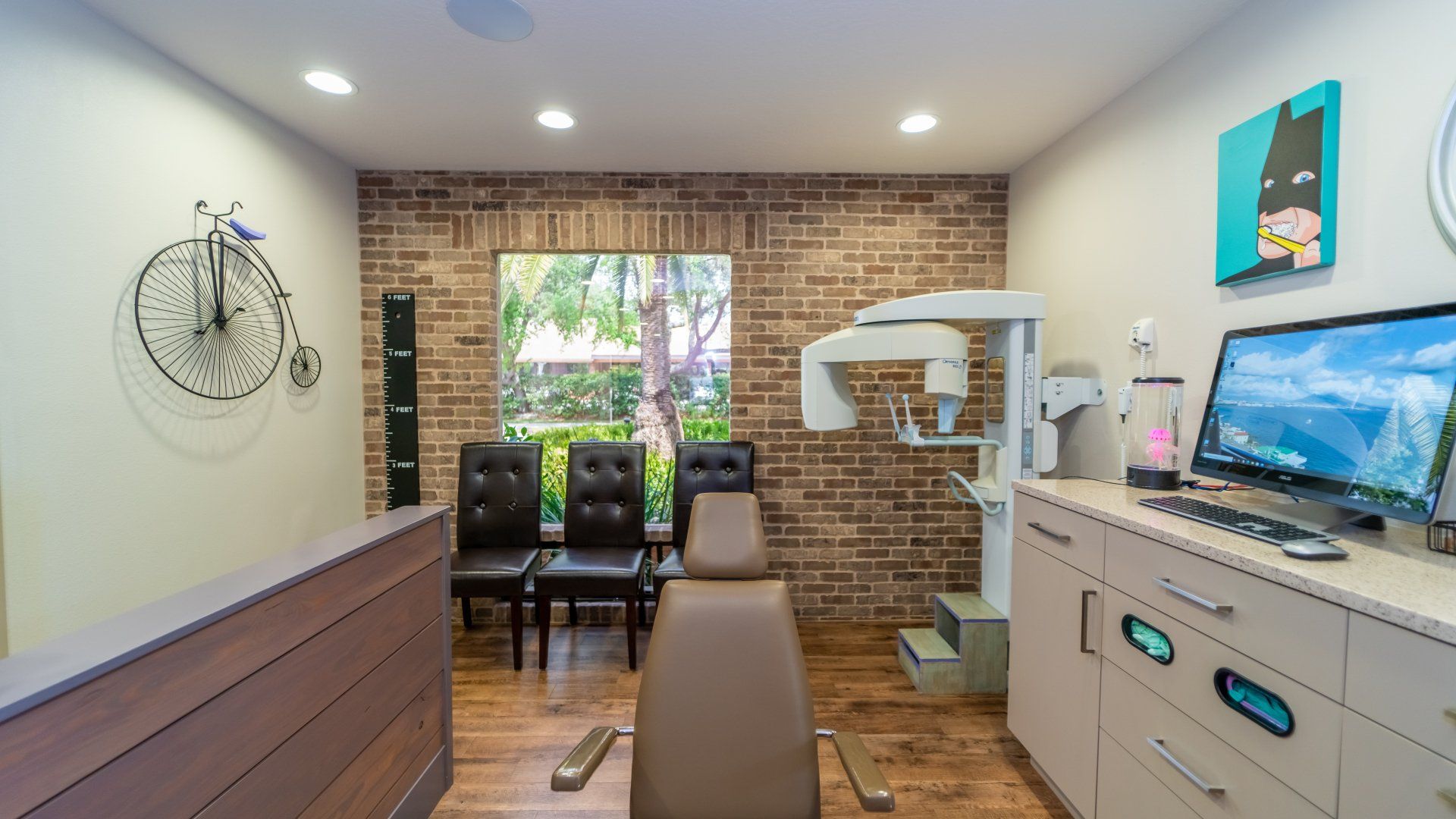 A dental office with a bicycle on the wall and a computer on the counter.