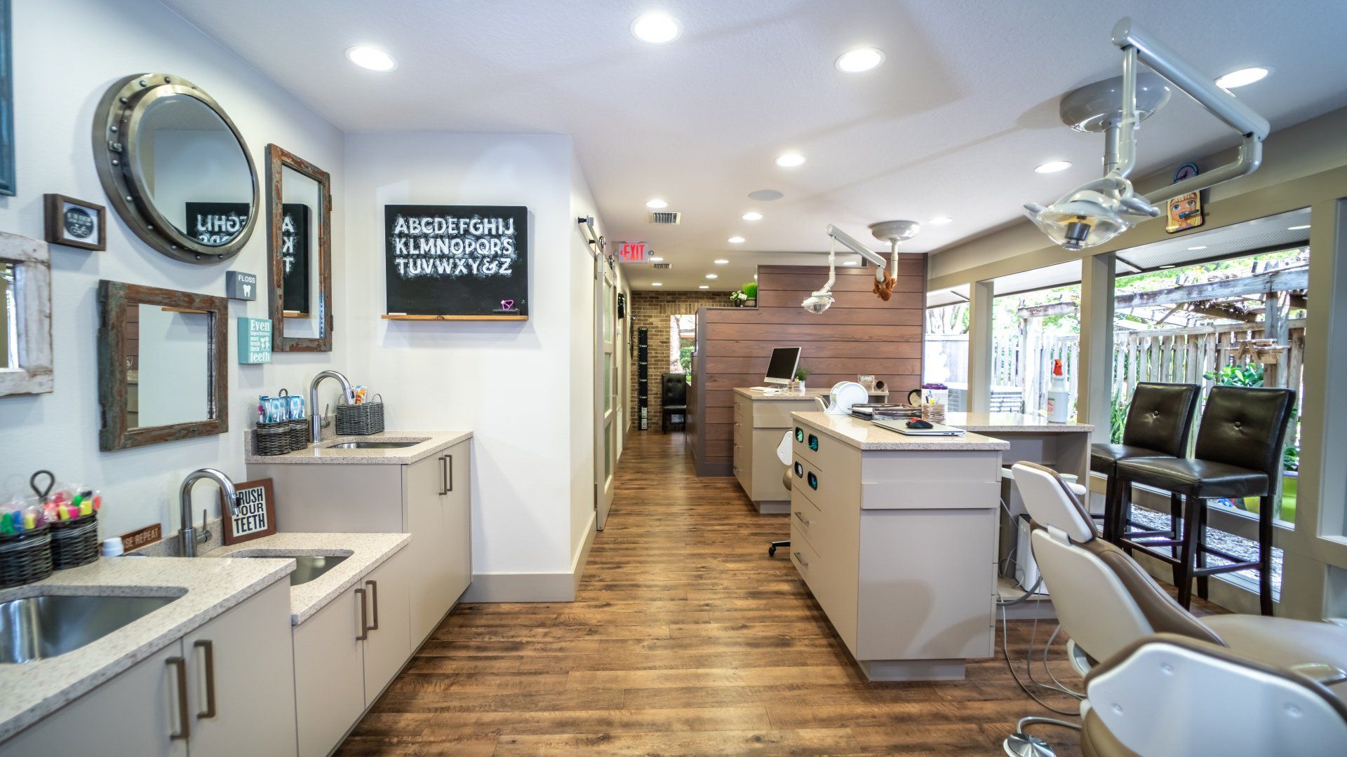 A dental office with a long hallway and a sink.