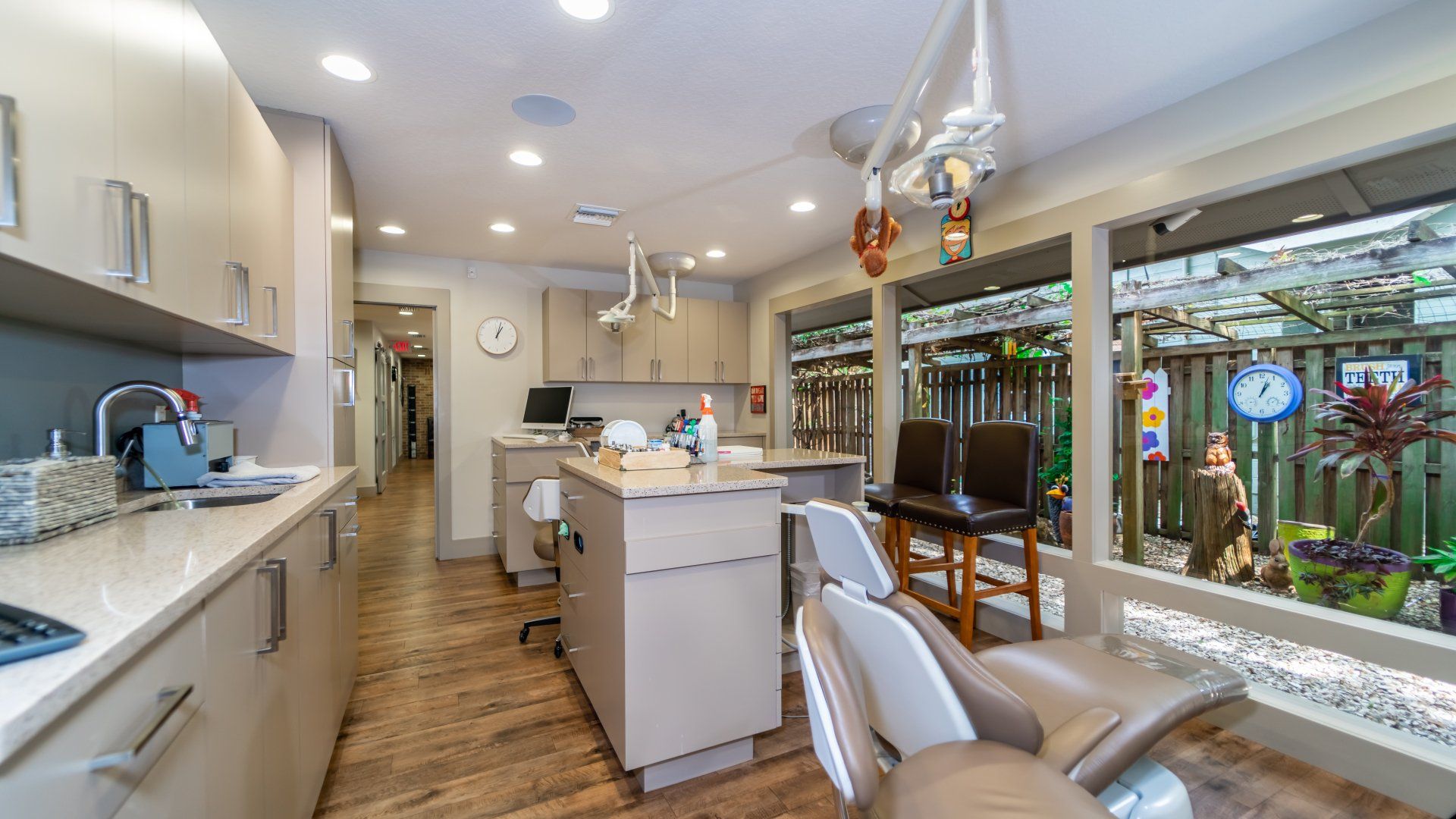A dental office with a lot of chairs and a sink.