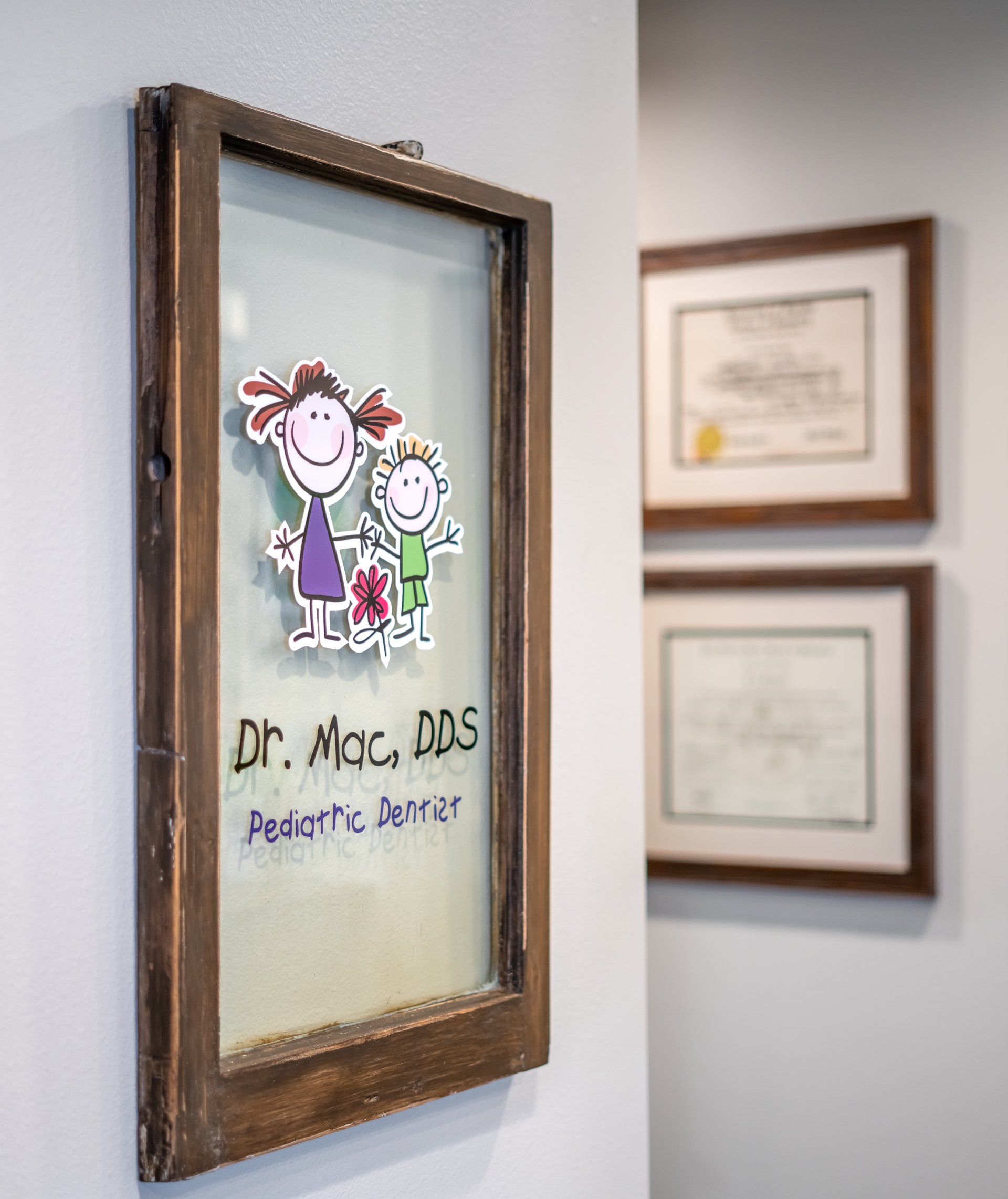 A picture frame with a picture of a girl and a boy on it is hanging on a wall.