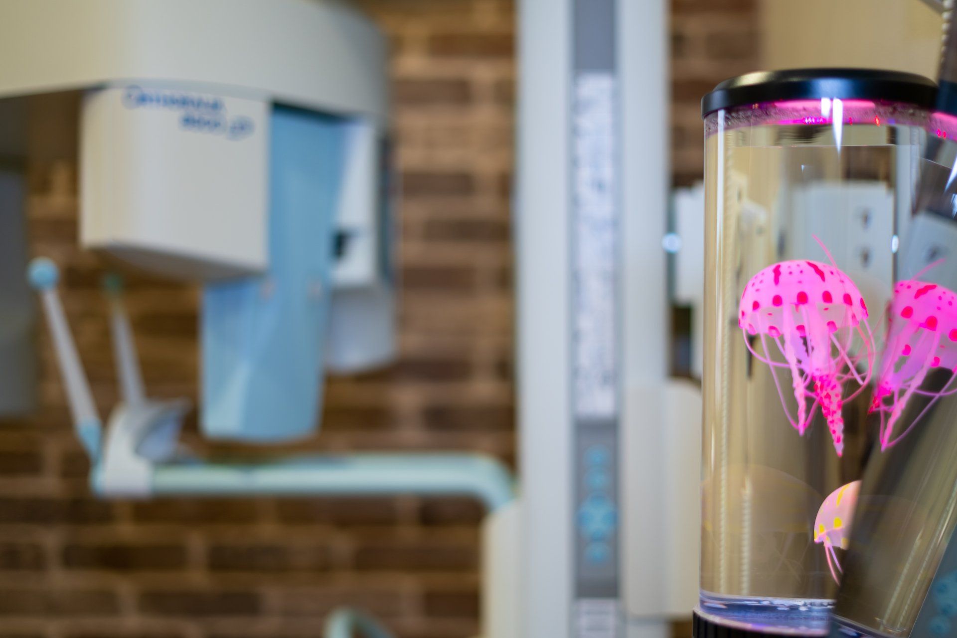 A jellyfish lamp is sitting in front of an x-ray machine in a dental office.