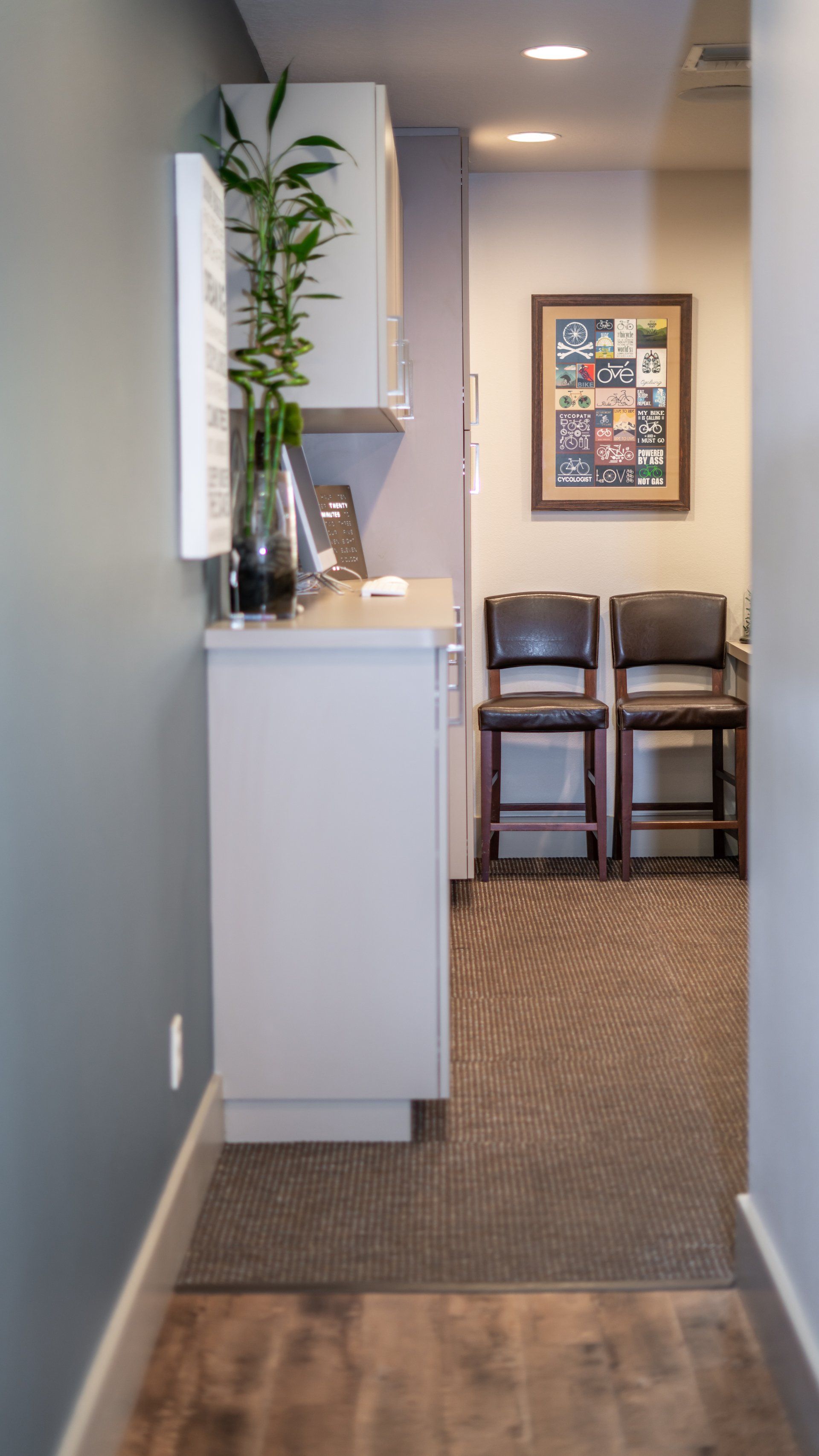 A hallway leading to a waiting room with chairs and a counter.