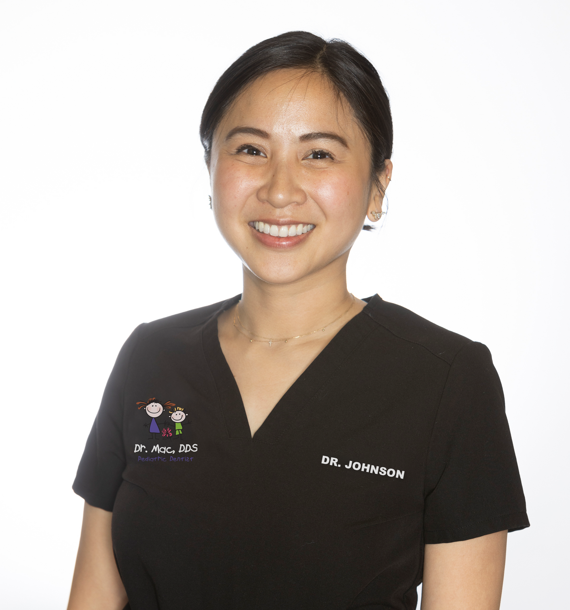 A woman wearing a black shirt and a black vest is smiling for the camera.