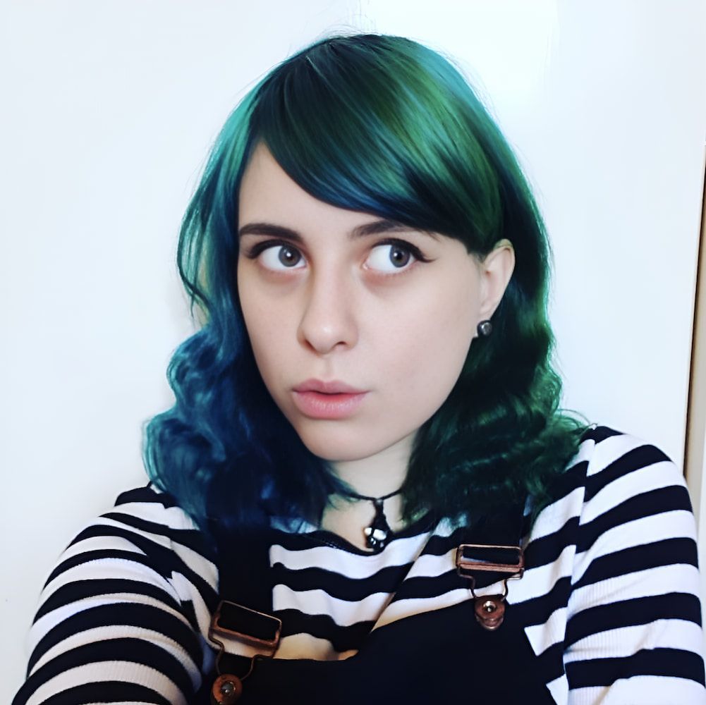 A Woman With Green Hair Is Wearing Overalls And A Striped Shirt — Howard Street Hair Studio In Nambour QLD