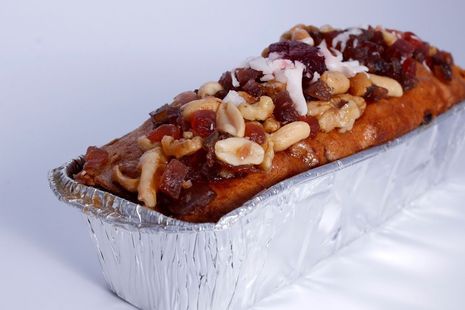Pan de nueces cubierto con nueces picadas en una bandeja para hornear de aluminio.