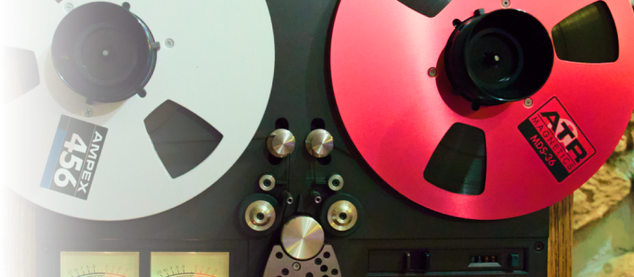 A reel-to-reel tape machine features a silver Ampex 456 tape reel on the left and a red ATR reel on the right.