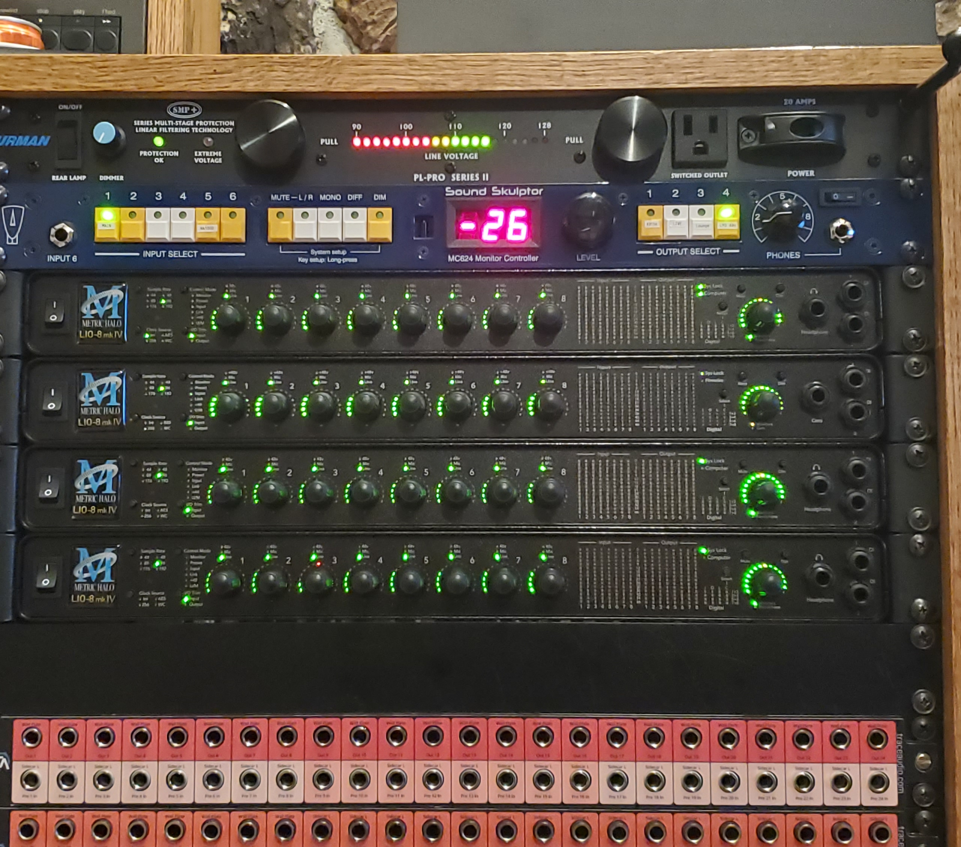 A rackmount audio setup with a power conditioner, four ART graphic equalizers, and a patch bay in a studio setting.