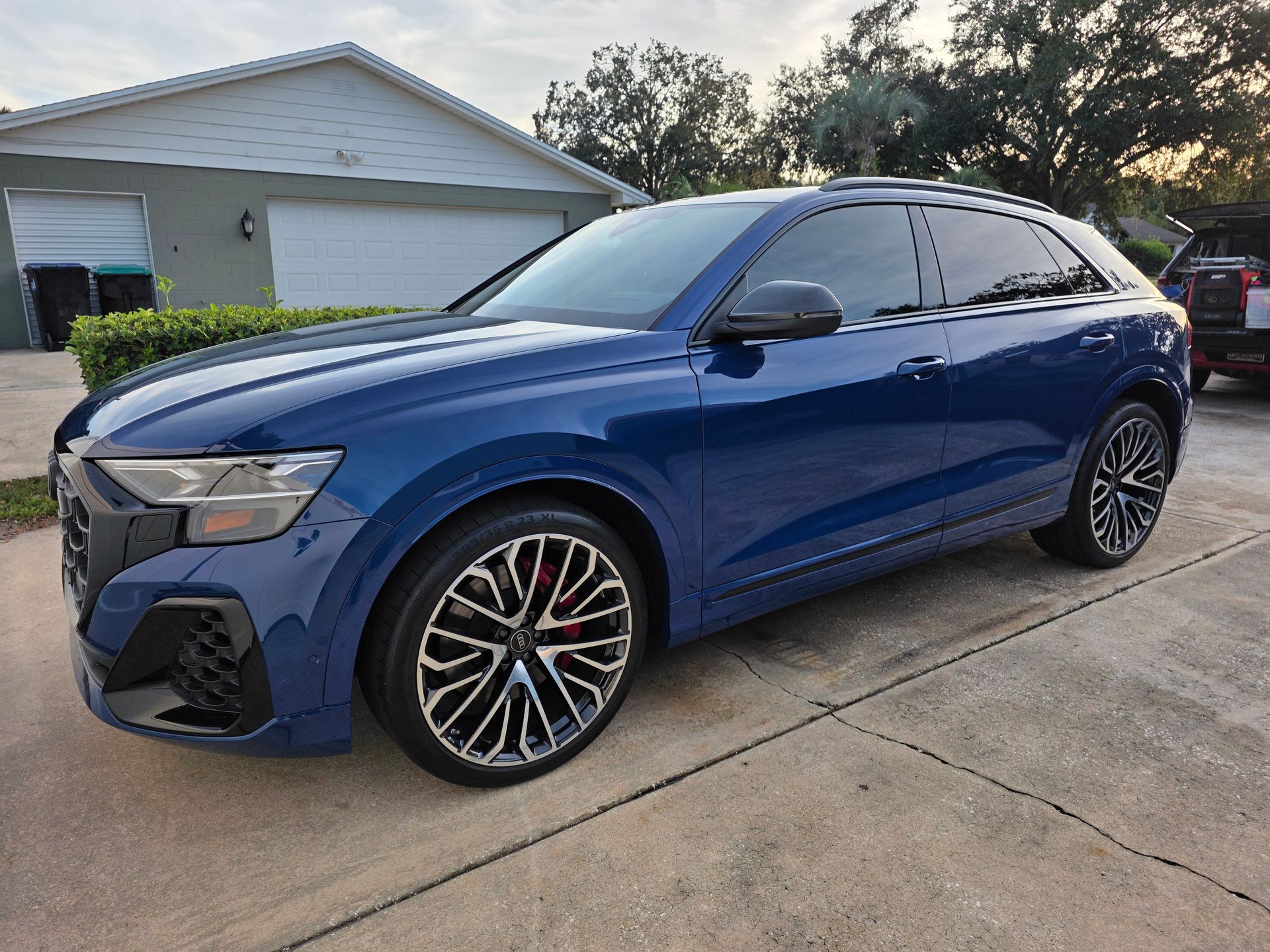 Blue Audi Q8 SUV parked on a driveway with tinted windows and black rims.