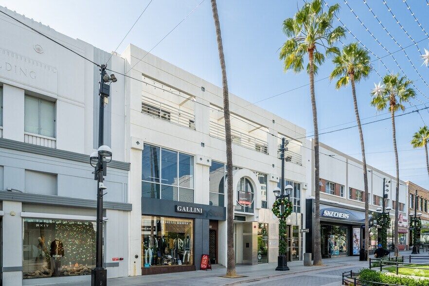 Modern two-story building with cars parked in front and American flag.