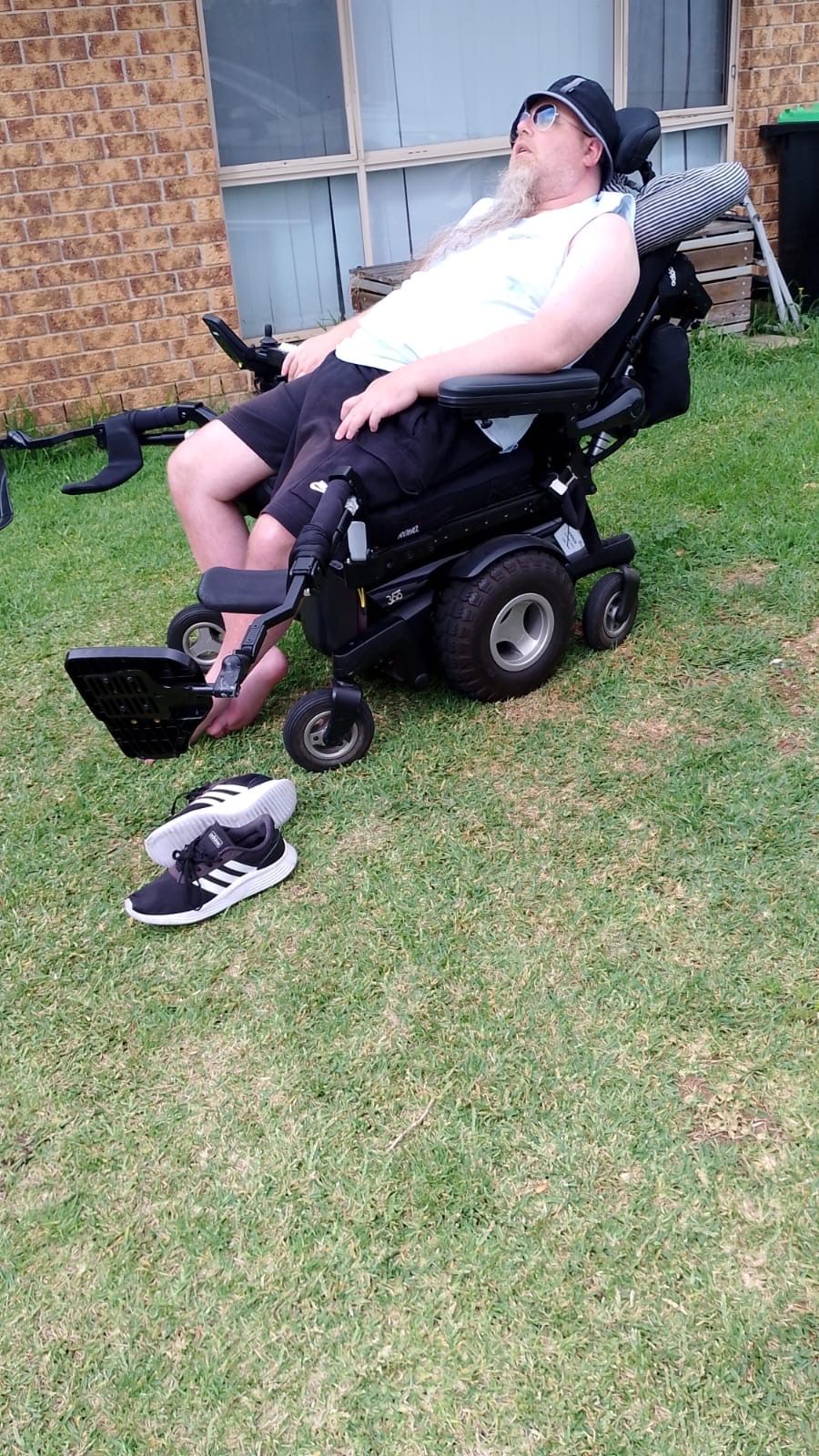 A man in a wheelchair is holding a bouquet of flowers.