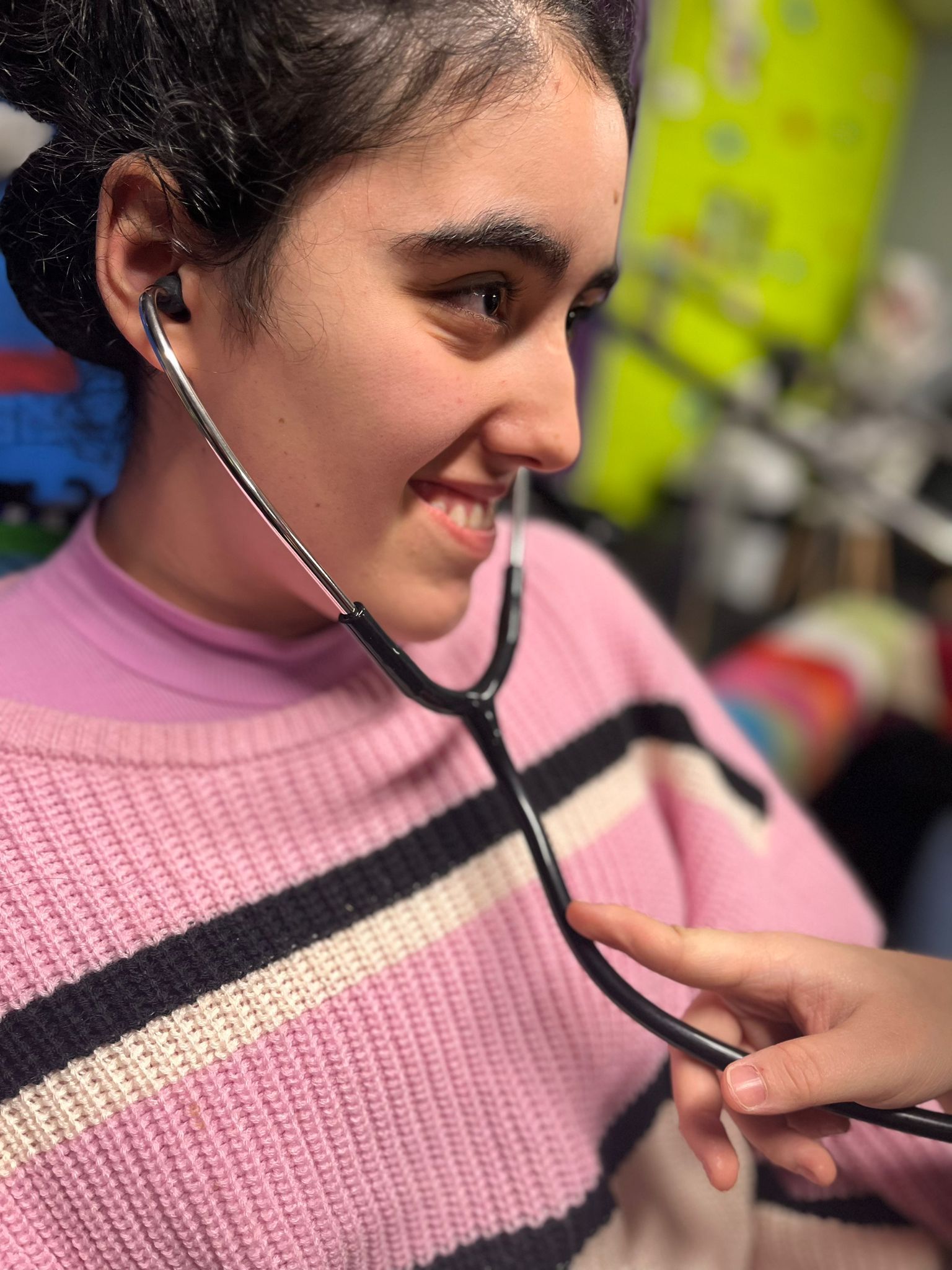 A woman is sitting in a chair hugging a dog.