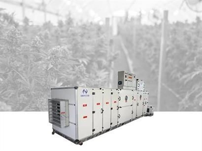 Large HVAC system in a greenhouse, with background of plants. 