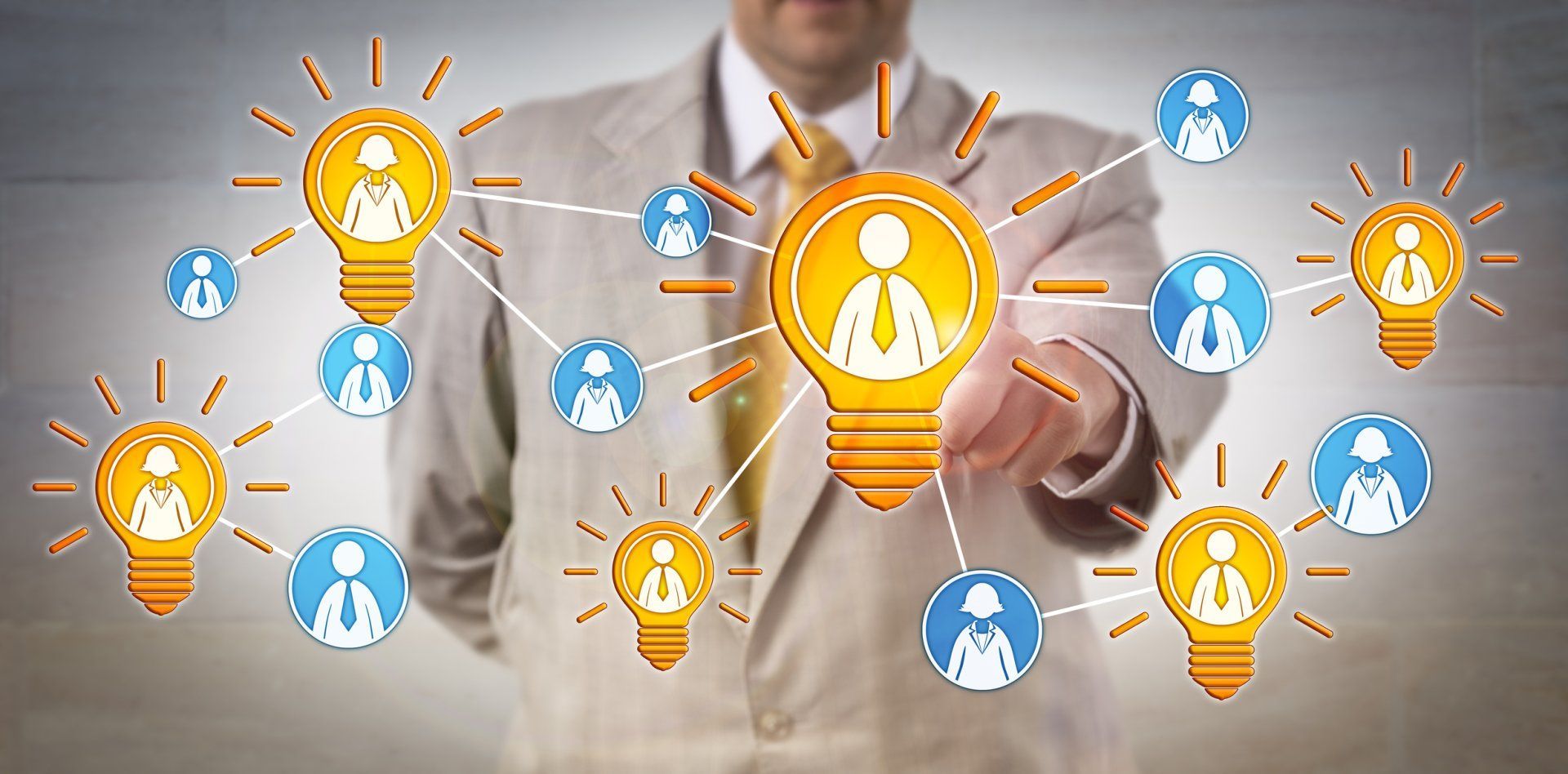 A man in a suit is pointing at a light bulb with a person in it.