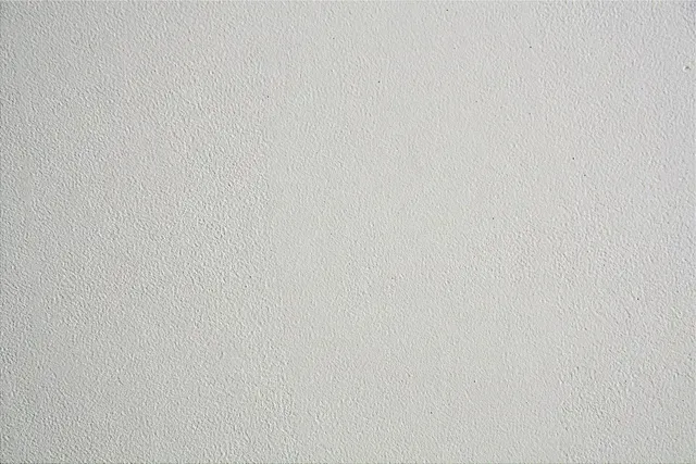 A close up of a white wall with a grainy texture.