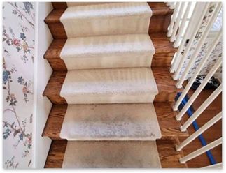 A staircase with a white carpet on the steps