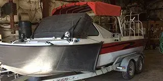 A boat is sitting on a trailer in a garage.