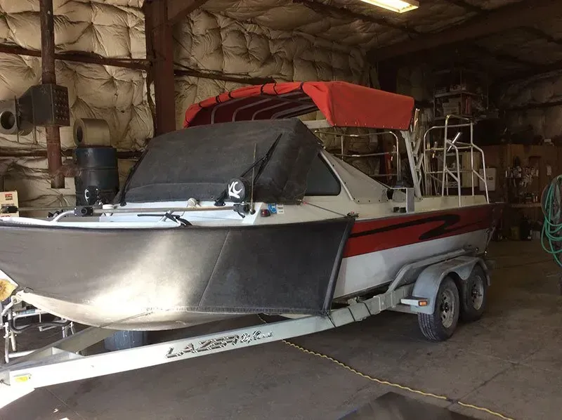 A boat is sitting on a trailer in a garage.