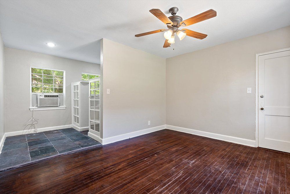 A living room with hardwood floors and a ceiling fan.