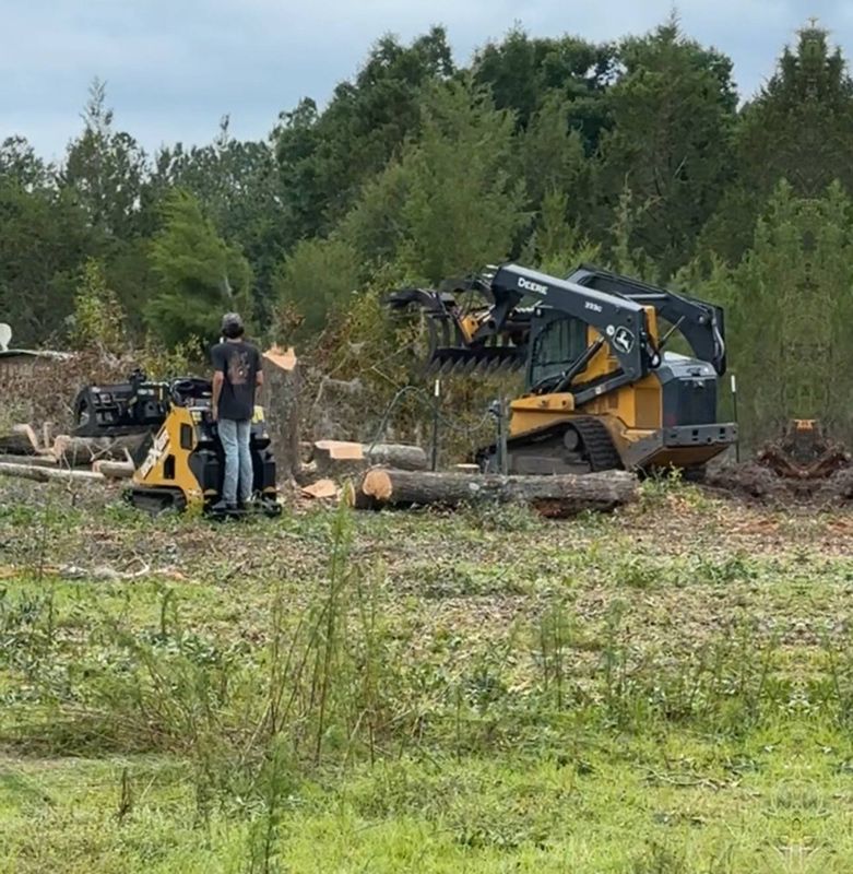 Worker with skid steer loader clearing the debris Worker with skid steer loader clearing the debris