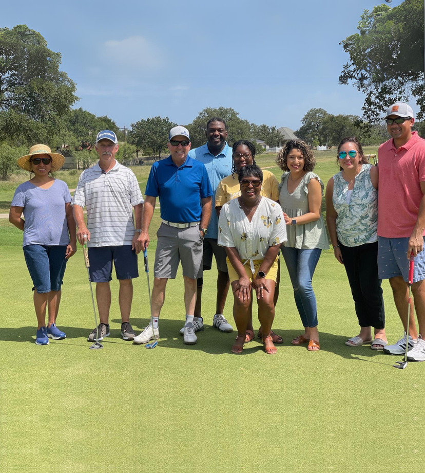 A group of people posing for a picture on a golf course at the 'Hill Country Cup'