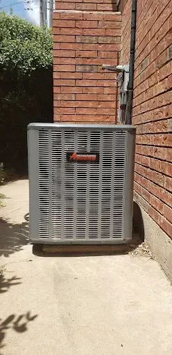 Bowling Heating & Conditioning LLC Spray Foam- An air conditioner is sitting on the side of a brick building.