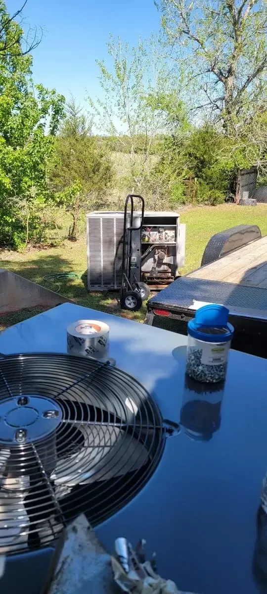 Bowling Heating & Conditioning LLC Spray Foam- An air conditioner is sitting on top of a table in a backyard.