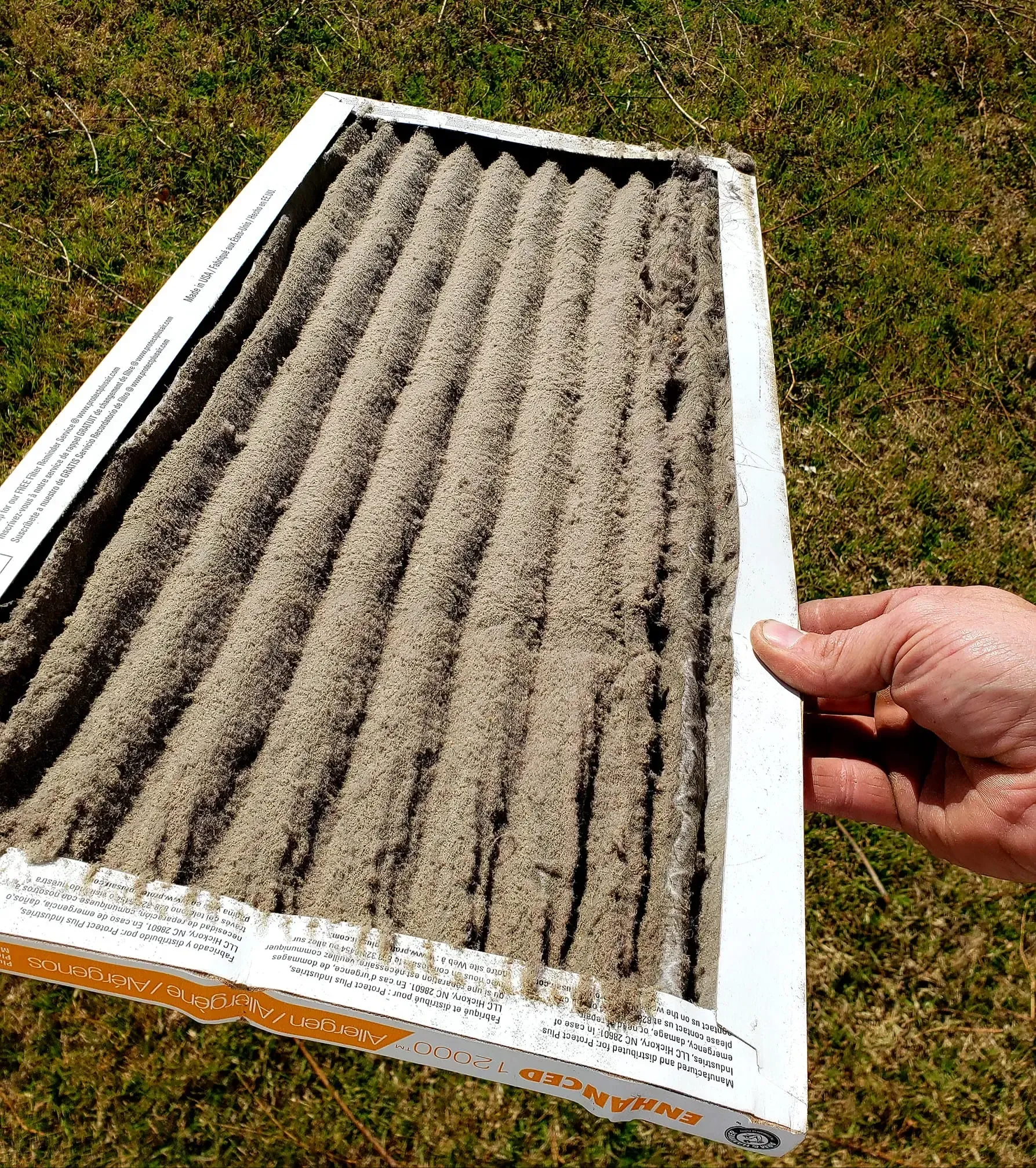 Bowling Heating & Conditioning LLC Spray Foam- A person is holding a dirty air filter in their hand.