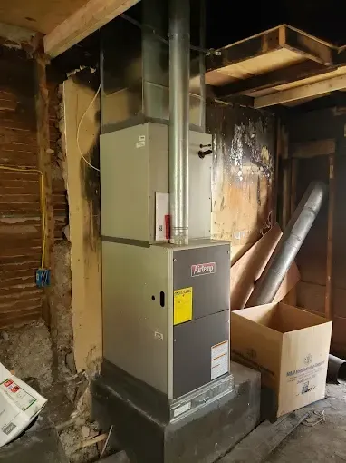 Bowling Heating & Conditioning LLC Spray Foam- A furnace is sitting in the corner of a room in a house.