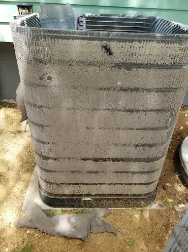 Bowling Heating & Conditioning LLC Spray Foam- A dirty air conditioner is sitting on the ground.