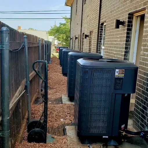 Bowling Heating & Conditioning LLC Spray Foam- A row of air conditioners are sitting outside of a brick building.