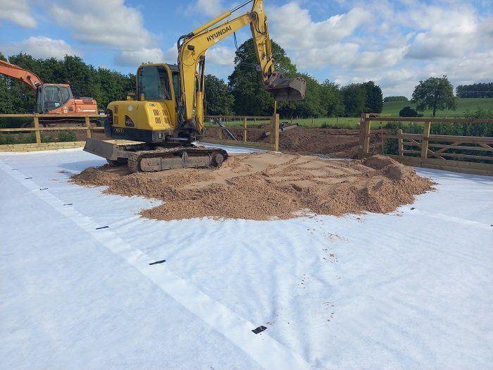 A yellow excavator is digging a hole in the ground
