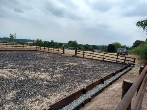 A dirt field with a wooden fence around it