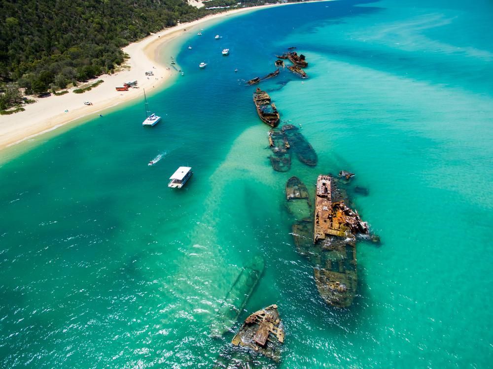 Aerial View of a Beach With Boats in the Water — Payless Timbers in Port Douglas, QLD