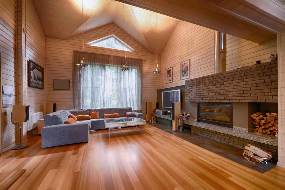 Living Room in a Wooden House With a Fireplace and a Couch — Payless Timbers in Cassowary Coast, QLD