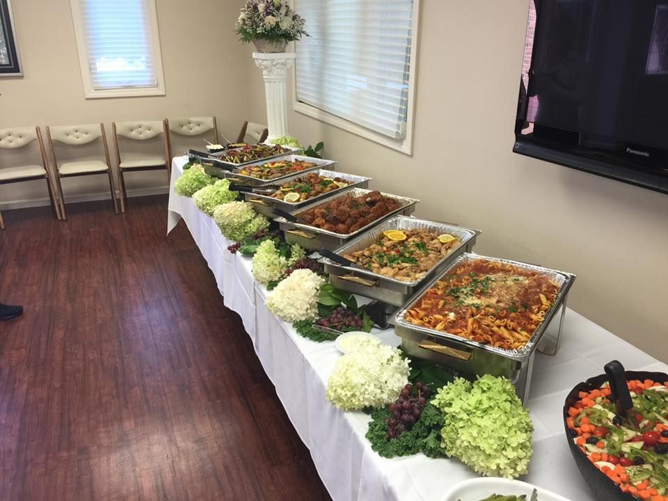 A long table with a variety of food on it.