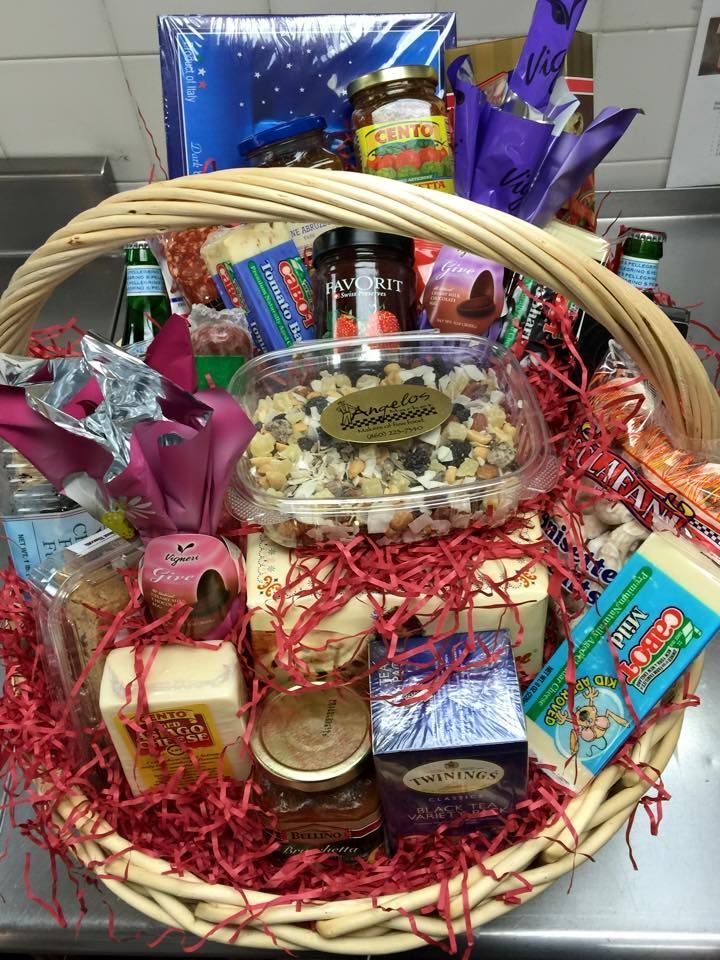 A wicker basket filled with a variety of food items is sitting on a counter.
