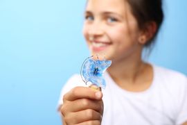 Girl holding dentofacial appliance